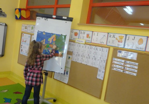 Dziewczynka wskazuje na mapie jeden z krajów Unii Europejskiej.